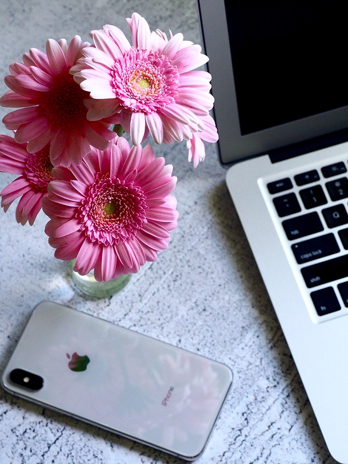 flowers on a table by phone and computer